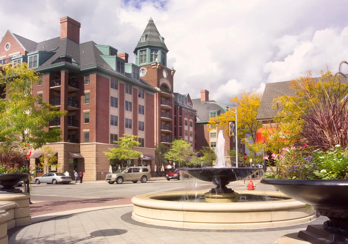 Scenic view of a town square with a fountain and colorful buildings.