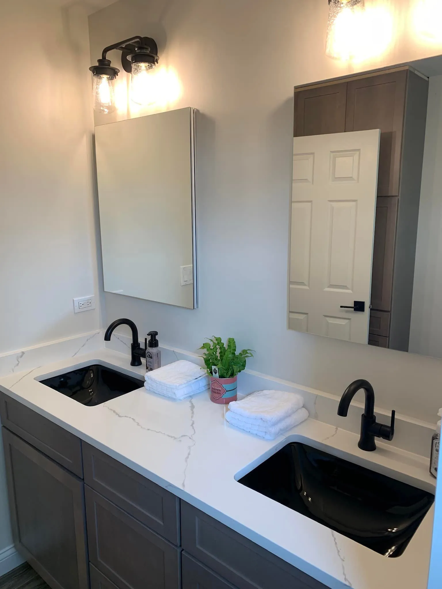 Modern bathroom sink with black fixtures and towels
